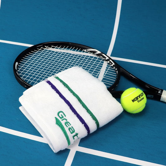 Tennis racket, towel, and ball on a blue court with GreatSpeed branding.